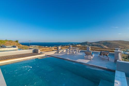 a swimming pool with a view of the ocean at Sunset junior suites in Agios Ioannis Tinos
