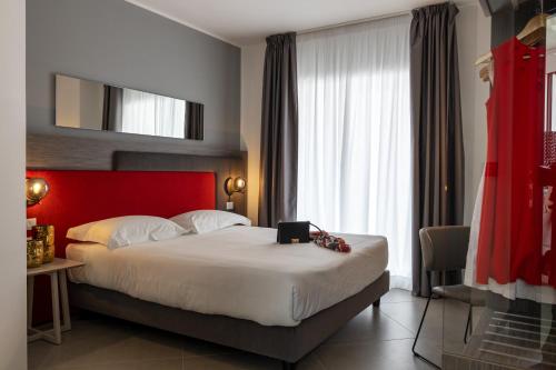 a hotel room with a large bed with a red headboard at Resort La Battigia Beach & Spa in Alcamo Marina