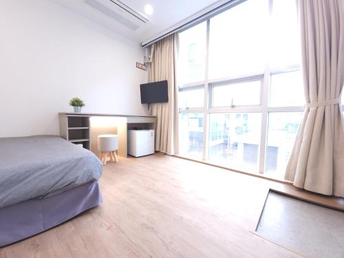 a bedroom with a bed and a large window at OYO Hostel Myeongdong 2 in Seoul