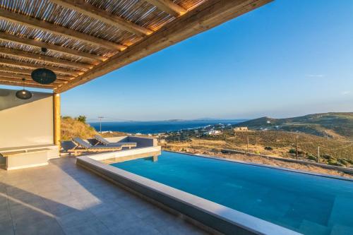 a villa with a swimming pool and a view at Sunset junior suites in Agios Ioannis Tinos