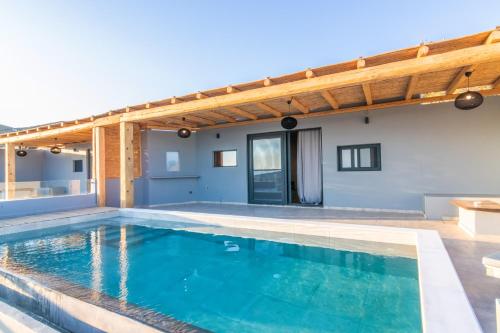 a swimming pool with a pergola on a house at Sunset junior suites in Agios Ioannis Tinos