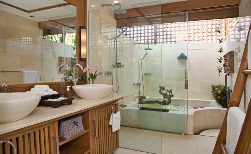バンラック・ビーチにあるUpni Duniya - Luxury, Beachfront 9-suites Villaの洗面台2つとシャワー付きのバスルーム