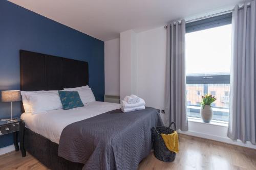 a bedroom with a bed and a large window at KSpace @ West One in Sheffield