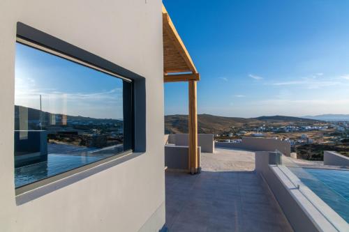 a view of the city from the balcony of a house at Sunset junior suites in Agios Ioannis Tinos