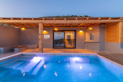 a swimming pool in the middle of a house at Sunset junior suites in Agios Ioannis Tinos
