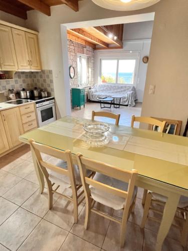 a kitchen with a yellow table and chairs and a room at Pelagia Apartments in Koroni