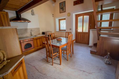 a kitchen with a table and chairs in a room at La Grandze in Allein
