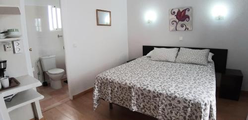 Dormitorio pequeño con cama y aseo en Hostal Nevada, en Fuengirola