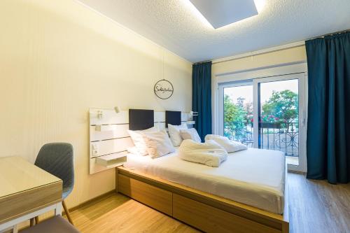 a bedroom with a large bed with a window at Pension Julia & Haus Elisabeth - Wallner's Hofheuriger & Weinhof in Mörbisch am See