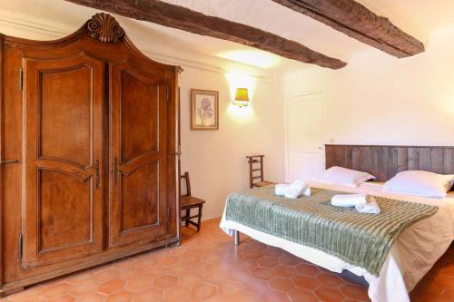 - une chambre avec un lit et une grande armoire en bois dans l'établissement Joli appartement dans une magnifique résidence calme avec parking- Benakey, à Cannes