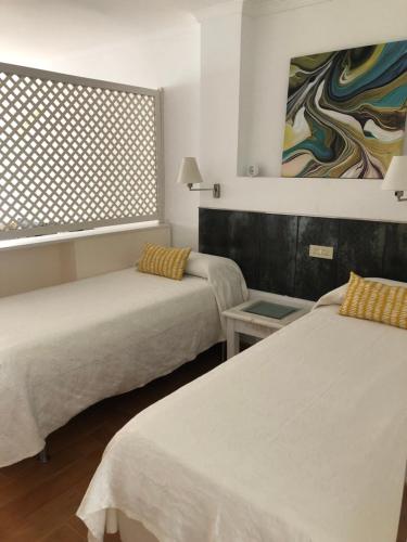 ラスパルマス・デ・グランカナリアにあるApartamento 511 Las Canterasのベッド2台と窓が備わる客室です。