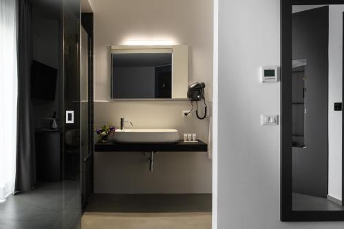 a bathroom with a sink and a mirror at Resort La Battigia Beach & Spa in Alcamo Marina