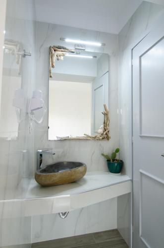 a bathroom with a stone sink and a mirror at Maria's View Delux in Ios Chora