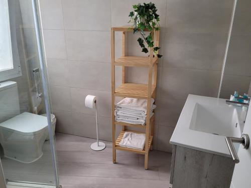a bathroom with a wooden towel rack next to a toilet at Apartamentos Bluebelle - Marbella in Marbella