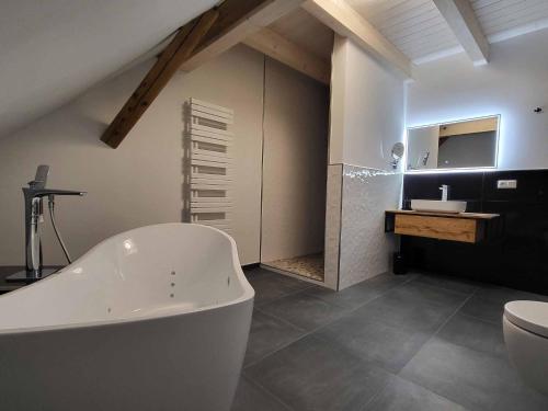 a bathroom with a white bath tub and a toilet at Ferienhof Gutmichel in Feuchtwangen