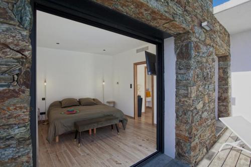 a bedroom with a bed and a stone wall at Casa Lina in Borgo