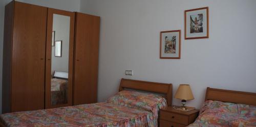 Habitación de hotel con 2 camas y espejo en Mar Menor apartments, en San Pedro del Pinatar