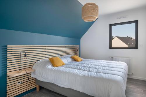 a bedroom with a large bed with a blue wall at Villa moderne avec piscine pour 15 personnes ! in Saint-Gildas-de-Rhuys