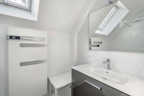 a white bathroom with a sink and a mirror at Villa moderne avec piscine pour 15 personnes ! in Saint-Gildas-de-Rhuys