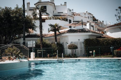 a swimming pool in front of a large building at Anais Marbella in Marbella