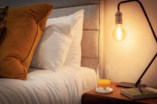 a bed with a pillow and a lamp on a table at No 5 Highwayman - Norfolk Cottage Agency in Sheringham