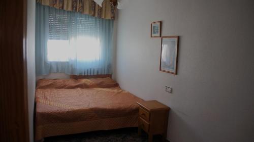 Habitación pequeña con cama y ventana en Mar Menor apartments, en San Pedro del Pinatar