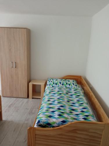 a bedroom with a bed and a wooden cabinet at Apartmán Hulín, Chrášťany in Hulín