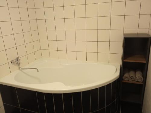 a bath tub with a faucet in a bathroom at Apartmán Hulín, Chrášťany in Hulín