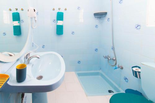 a blue bathroom with a sink and a tub at Appartement Familial au Centre Miramar in Martil
