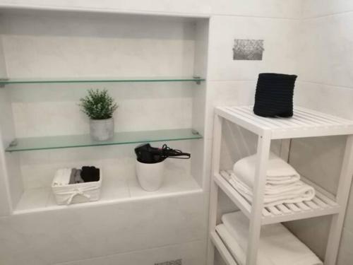 baño con bañera blanca y estante blanco en Casa Levante, en Monopoli