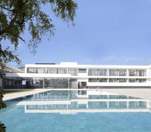 - une vue extérieure sur un bâtiment avec une piscine dans l'établissement Porto Covo Praia Hotel & SPA, à Porto Covo