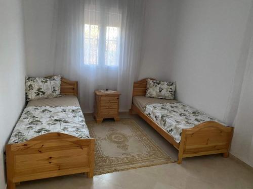 a bedroom with two beds and a window at Villa DJERBA La Douce in Midoun