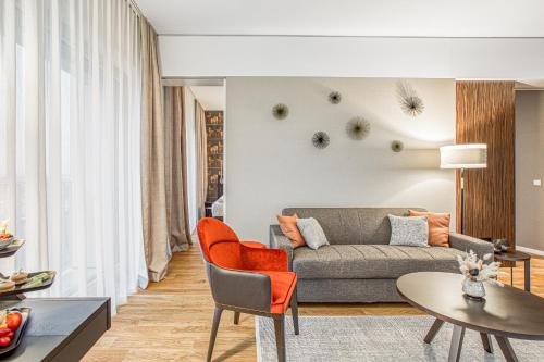 a living room with a couch and a table at Parkhotel Heilbronn in Heilbronn