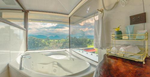 baño con bañera y ventana en Hotel La Hacienda, en Quesada