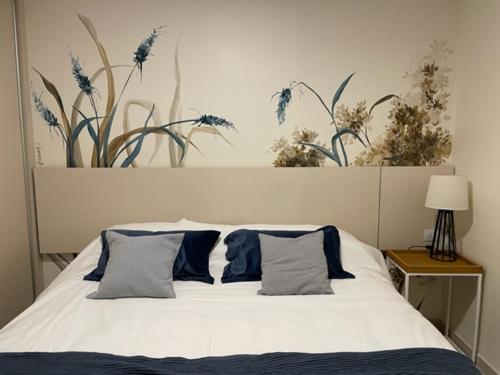 ein weißes Bett mit blauen Kissen im Schlafzimmer in der Unterkunft Departamentos boutique in La Falda