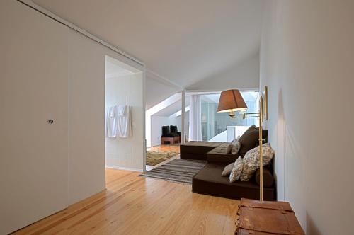 a living room with a couch and a lamp in a room at Portas do Castelo Apartments in Lisbon
