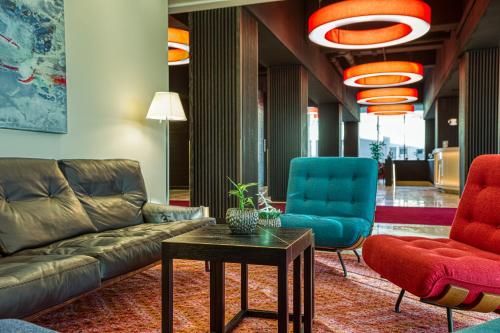 a living room with a couch and two chairs at Parkhotel Heilbronn in Heilbronn