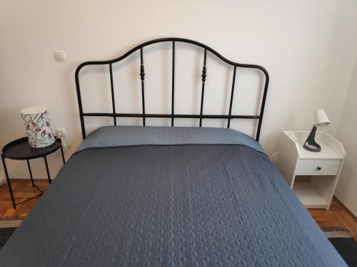 a bedroom with a bed with a metal head board at Apartman Ema in Tar