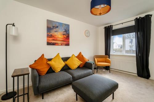 a living room with a couch and an orange chair at Modern 3-Bed Family Home Near Glasgow Airport in Bishopton