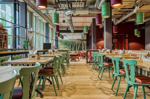 a restaurant with wooden tables and green chairs at Parkhotel Heilbronn in Heilbronn