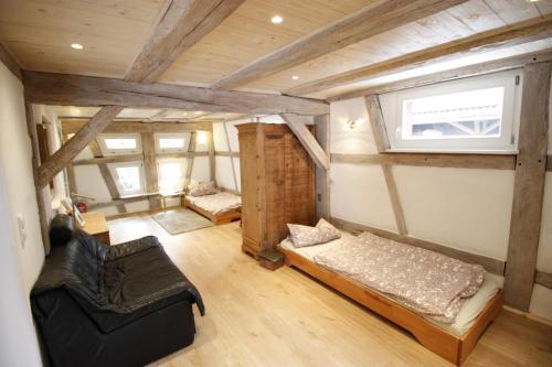 a room with a bed and a couch and a window at Gemütliche Gästezimmer in einem neu sanierten Fachwerkhaus in Sachsenheim