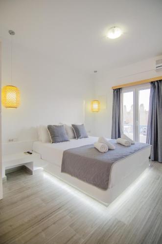 a white bedroom with a large bed and a window at Maria's View Delux in Ios Chora