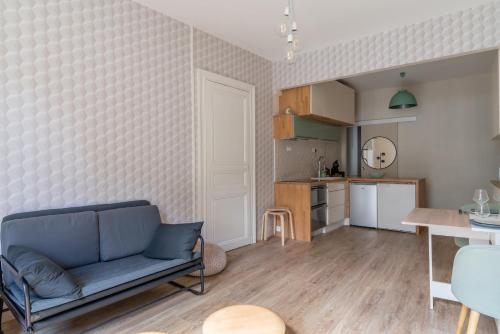 un salon avec un canapé bleu et une cuisine dans l'établissement Appartement confortable au cœur de Nantes, à Nantes