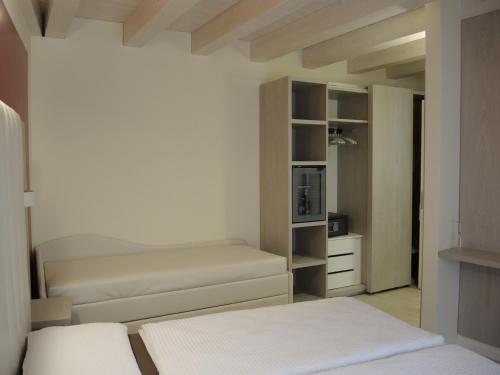 a bedroom with two beds and a closet at Bed and Breakfast Casa Mosole in Malcesine