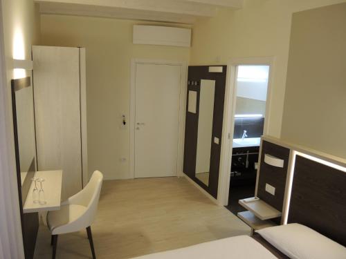 a room with a bed and a desk and a mirror at Bed and Breakfast Casa Mosole in Malcesine