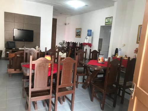 a dining room with tables and chairs and a tv at Pousada flor de Atibaia in Atibaia