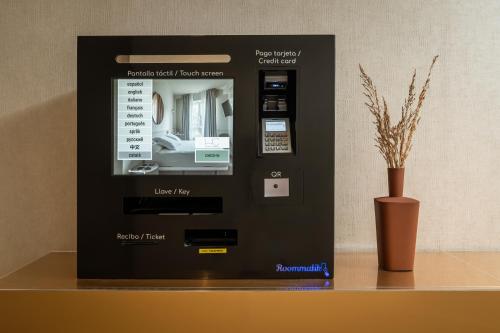 a machine sitting on a table next to a vase at BYPILLOW The Bloom in Girona