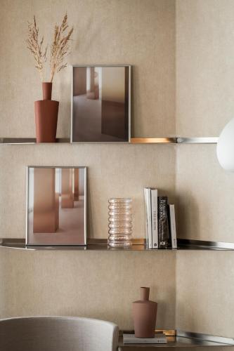 a wall with shelves with two mirrors and a table at BYPILLOW The Bloom in Girona