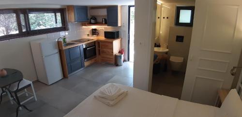 a kitchen with blue cabinets and a white refrigerator at Artemis Village Apartments & Studios in Stavros