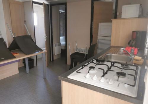 eine Küche mit Herd und Spüle in der Unterkunft Mobil-Home 6 Places (3 chambres) tout équipé in Soulac-sur-Mer